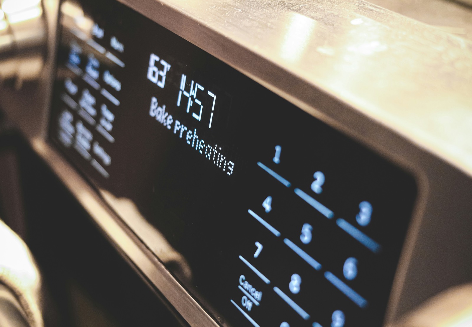 Close-up of an oven control panel with the display reading "Bake preheating"